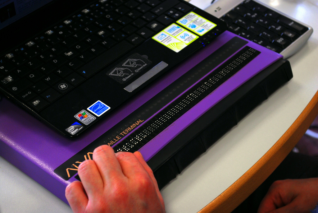 Hand on braille purple display